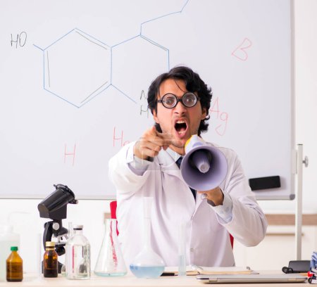 Téléchargez les photos : Le jeune chimiste drôle devant le tableau blanc - en image libre de droit
