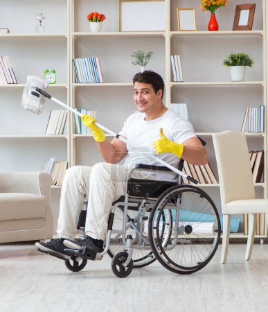 Foto de El hombre discapacitado limpiando piso en casa - Imagen libre de derechos