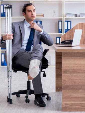 Téléchargez les photos : L'employé masculin blessé à la jambe dans le bureau - en image libre de droit