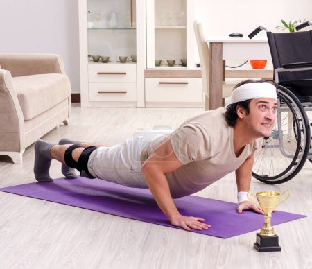 Photo for The injured young man doing exercises at home - Royalty Free Image