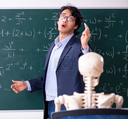 Téléchargez les photos : Le jeune homme professeur de mathématiques et squelette étudiant - en image libre de droit