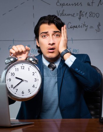 Foto de El especialista financiero que trabaja hasta tarde en la oficina - Imagen libre de derechos