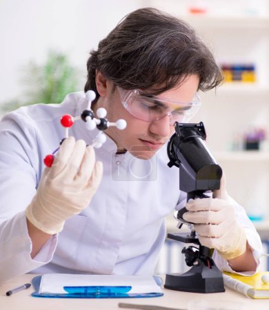 Téléchargez les photos : Le jeune biochimiste masculin travaillant dans le laboratoire - en image libre de droit