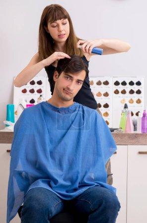 Foto de El joven atrayente hombre visitando peluquero femenino - Imagen libre de derechos