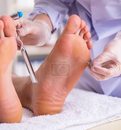 Foto de El podólogo que trata los pies durante el procedimiento - Imagen libre de derechos