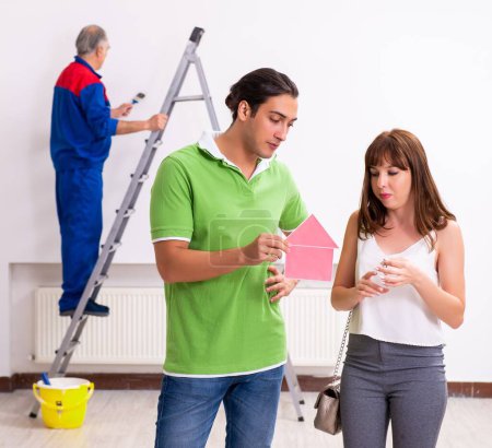 Photo for Young couple and old contractor in the home renovation concept - Royalty Free Image
