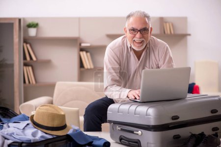 Téléchargez les photos : Aged man preparing for trip at home - en image libre de droit