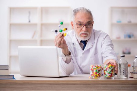 Foto de Viejo doctor sosteniendo modelo molecular - Imagen libre de derechos