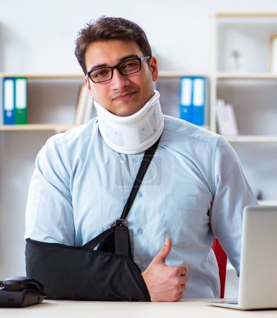 Téléchargez les photos : L'homme d'affaires avec le bras cassé travaillant dans le bureau - en image libre de droit