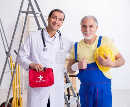 Photo for Young doctor and old contractor in first aid concept - Royalty Free Image