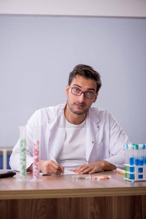 Téléchargez les photos : Young chemist in front of white board - en image libre de droit