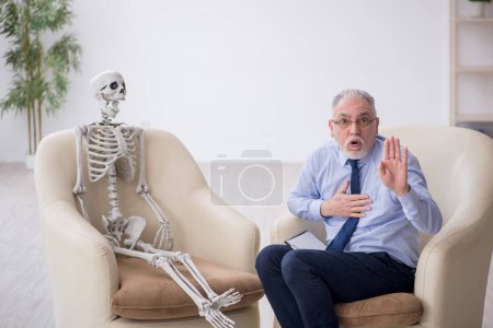 Photo for Old psychologist meeting with skeleton - Royalty Free Image