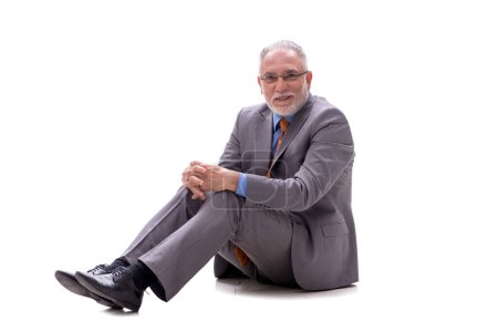 Téléchargez les photos : Homme d'affaires âgé assis sur le sol isolé sur blanc - en image libre de droit