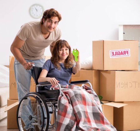 Téléchargez les photos : Le mari avec femme handicapée déménageant dans un nouvel appartement - en image libre de droit