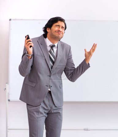 Photo for The young handsome businessman standing in front of whiteboard - Royalty Free Image