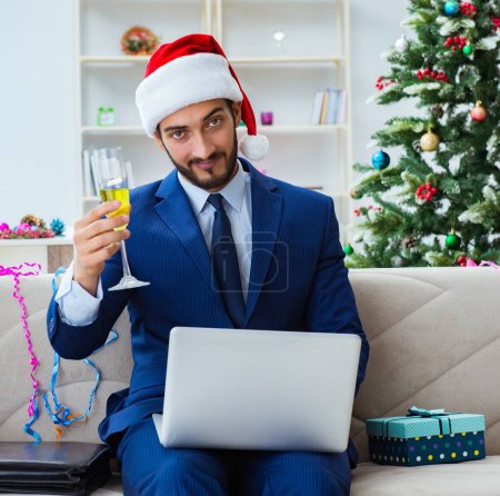 Foto de El hombre de negocios trabajando en casa durante la Navidad - Imagen libre de derechos
