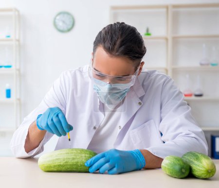 Foto de El experto en nutrición masculina prueba verduras en el laboratorio - Imagen libre de derechos