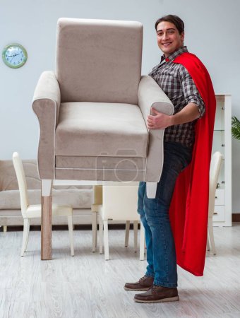 Foto de El súper héroe moviendo muebles en casa - Imagen libre de derechos