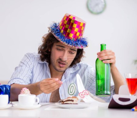 Téléchargez les photos : Le jeune homme fête son anniversaire à la maison - en image libre de droit