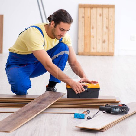 Photo for The young male contractor working indoors - Royalty Free Image