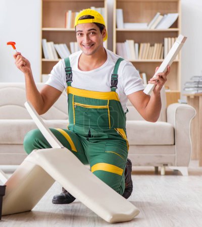 Téléchargez les photos : Le travailleur répare les meubles à la maison - en image libre de droit