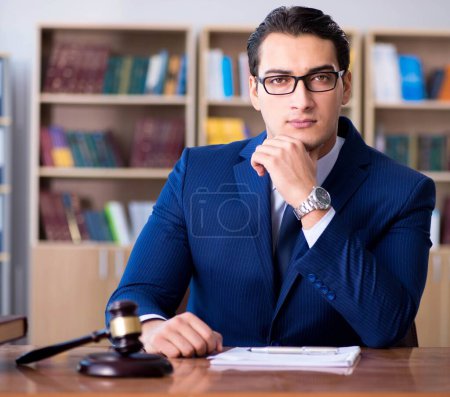 Photo for The handsome judge with gavel sitting in courtroom - Royalty Free Image