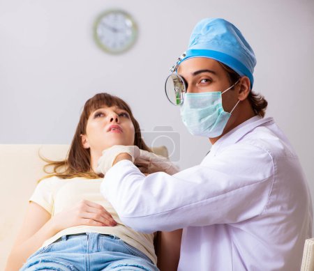 La joven mujer visting médico otorrinolaringólogo masculino