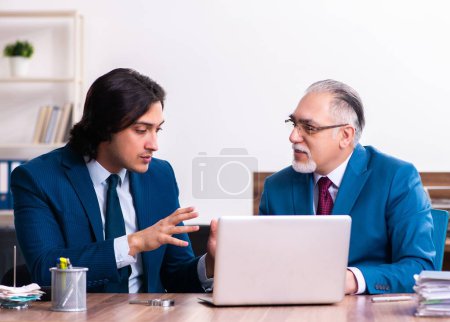 Téléchargez les photos : Les jeunes et les vieux employés qui travaillent ensemble au bureau - en image libre de droit