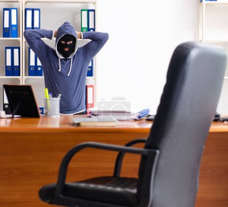 Photo for The male thief in balaclava in the office - Royalty Free Image