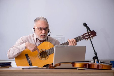 Téléchargez les photos : Vieux professeur de musique en classe - en image libre de droit