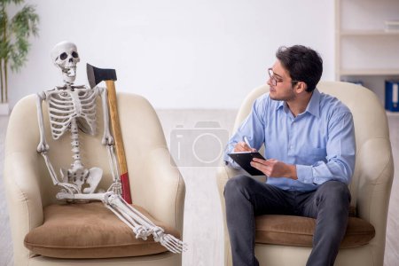 Foto de Joven psicólogo reunión con esqueleto - Imagen libre de derechos