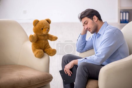 Téléchargez les photos : Jeune psychologue rencontre avec l'ours jouet - en image libre de droit