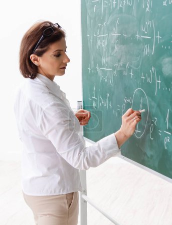 Photo for The female math teacher in front of the chalkboard - Royalty Free Image