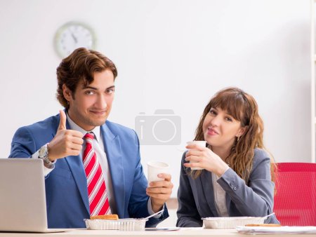 Téléchargez les photos : Les deux collègues en pause déjeuner sur le lieu de travail - en image libre de droit