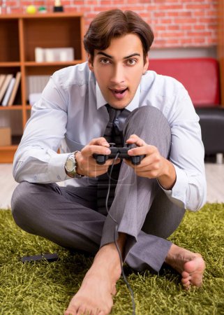 Téléchargez les photos : The young employee playing joystick games during his break - en image libre de droit