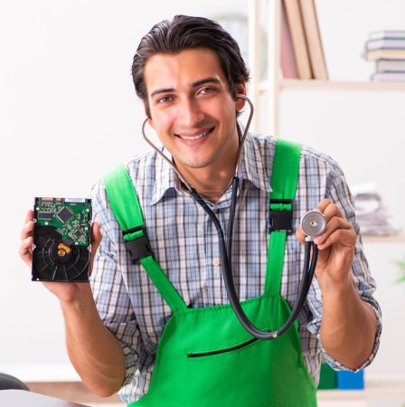 Photo for The young engineer repairing broken computer at the office - Royalty Free Image
