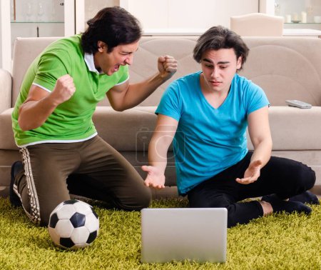Foto de Los amigos viendo fútbol en casa - Imagen libre de derechos