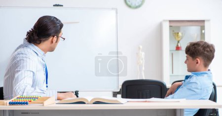 Photo for The young father helping his son to prepare for exam - Royalty Free Image