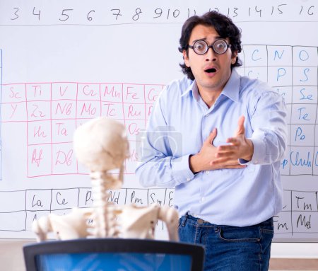 Téléchargez les photos : Le jeune homme chimiste professeur et squelette étudiant - en image libre de droit