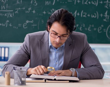Téléchargez les photos : Le jeune beau professeur de mathématiques en classe - en image libre de droit