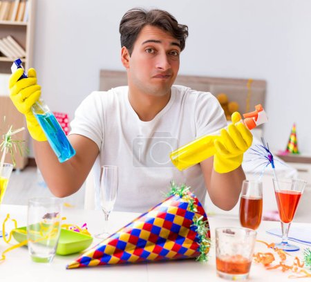 Téléchargez les photos : L'homme qui nettoie la maison après la fête de Noël - en image libre de droit
