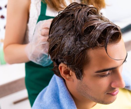 Photo for The woman hairdresser applying dye to man hair - Royalty Free Image