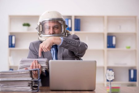 Foto de Old employee wearing spacesuit in the office - Imagen libre de derechos
