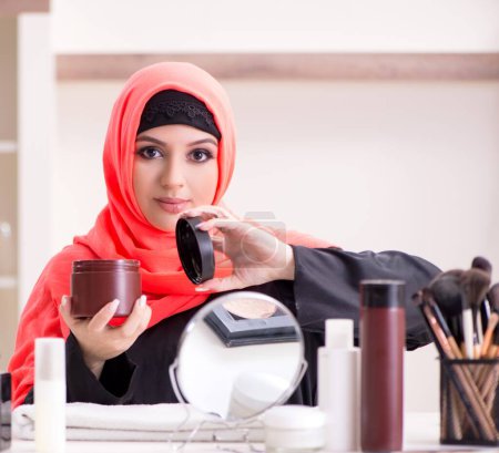 Photo for The beautiful woman in hijab applying make-up - Royalty Free Image