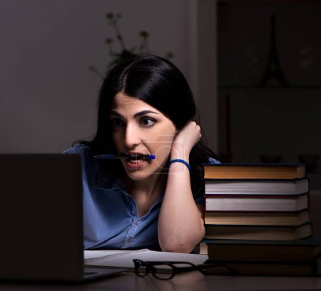 Photo for The young female student preparing for exams at night time - Royalty Free Image