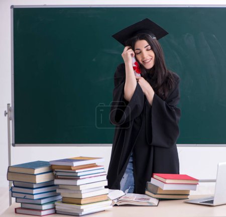 Téléchargez les photos : The female graduate student in front of green board - en image libre de droit