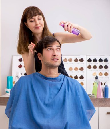 Photo for The young attracrive man visiting female barber - Royalty Free Image