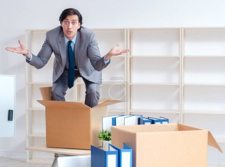 Photo for The young man employee with boxes in the office - Royalty Free Image
