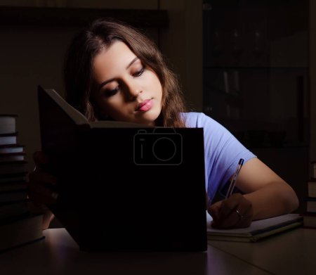Photo for The young female student preparing for exams late at home - Royalty Free Image