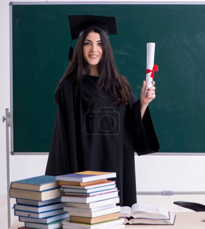 Foto de The female graduate student in front of green board - Imagen libre de derechos
